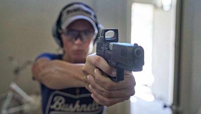 Woman holding a pistol with the Bushnell RXS-250 Reflex Sight